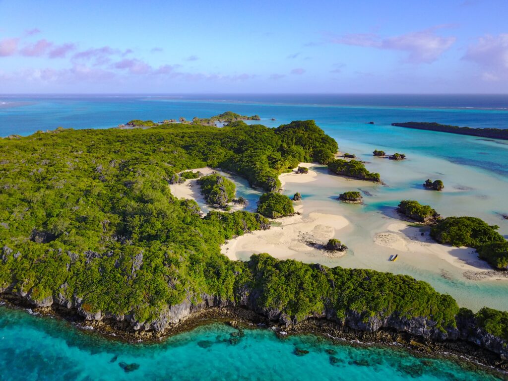 Eagle eye view of an island with lots of green trees.