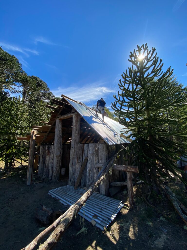 A person working on the roof of a partially built home.